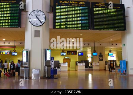 Check-in-Schalter und Fluginformationsbrett im Malaga Airport Terminal, Málaga, Spanien. Stockfoto