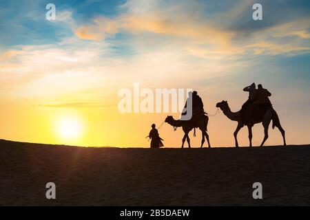 Tourist auf Kamel zurück in Silhouette bei Sonnenuntergang bei Thar deser Jaisalmer Rajasthan, Indien Stockfoto