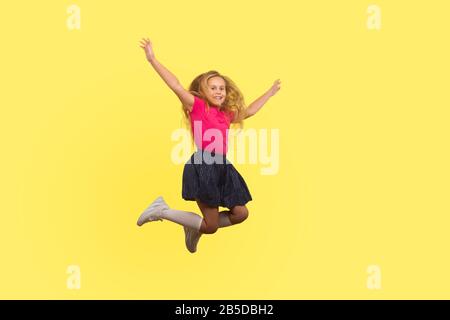 Lange Portrait des schönen kleinen Mädchens mit langen blonden Haaren im Kleid, das in Luft springt, das Kind inspiriert hat zu fliegen und unbeschwertes Leben zu feiern. Indoo Stockfoto