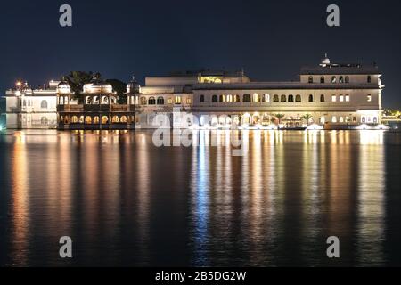 Palace Hotelarchitektur am See Pichola nachts mit Wasserspiegelung im Udaipur Rajasthan, Indien Stockfoto