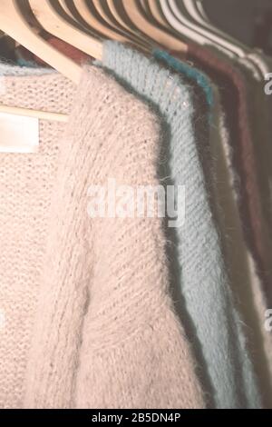 Sammlung warmer Pullover für Frauen, die auf einem Regal hängen. Stockfoto