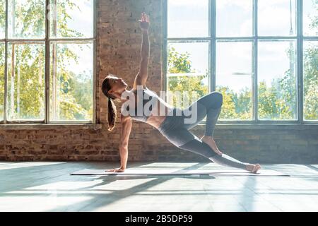 Junge sportliche Mädchen üben Hatha Yoga-Seitenplanke Haltung gesunder Lebensstil. Stockfoto