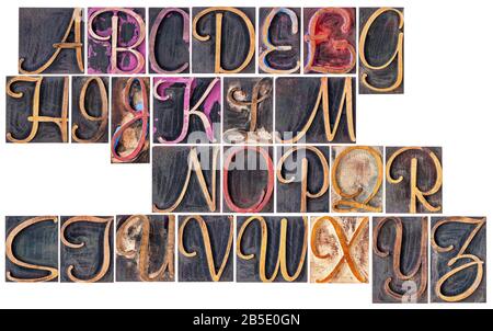 Komplettes englisches Alphabet in ornamentaler Schrift Holzart - eine Collage von 26 isolierten Briefpress-Druckblöcken, die durch Farbe und schwarze Tinte befleckt sind Stockfoto