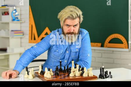 Entwicklungslogiken. Schullehrer. Schach spielen. Intellektuelles Hobby. Figuren auf Holzschachbrett. Schach ist selten das Spiel idealer Bewegungen. Schachstunde. Strategiekonzept. Denken Sie an den nächsten Schritt. Stockfoto