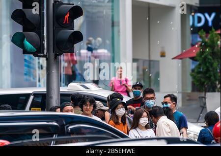 Kuala Lumpur, Malaysia. März 2020. Menschen, die Masken tragen, gehen auf einer Straße in Kuala Lumpur, Malaysia, 8. März 2020. Sechs neue Fälle von COVID-19 wurden am Sonntag in Malaysia gemeldet, was die Gesamtzahl der Fälle auf 99 brachte, sagte das Gesundheitsministerium. Credit: Zhu Wei/Xinhua/Alamy Live News Stockfoto