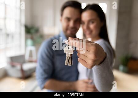 Konzentrieren Sie sich auf Schlüssel, die von aufgeregten jungen Hausbesitzern gehalten werden. Stockfoto