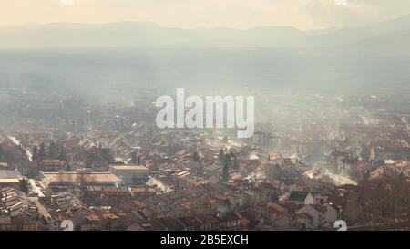 Weiche, dunstige Sicht auf Smog über der Stadt, verschmutzt durch Rauch aus Kaminen der Häuser mit Holz für die Heizung Stockfoto