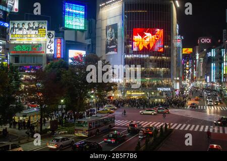 Nachtaufnahmen von Fußgängern, die eine vierstreifige Zebraüberquerung am Shibuya Crossing im Zentrum Tokios, Japan, überqueren Stockfoto