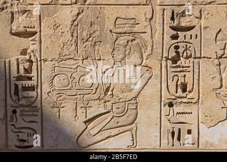 Hieroglypische Schnitzereien an der Wand am altägyptischen Tempel von Medinat Habu in Luxor Stockfoto