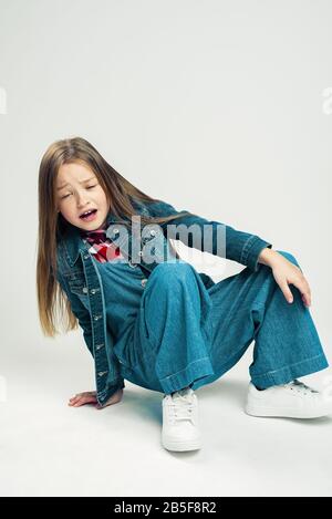 Das kleine Mädchen ist gefallen. Kind zeigt Emotionen verletzt. Frustriertes Kind. Studiofotografie. Stockfoto