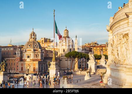 Luftaufnahme der Kuppeln der Kirche Santa Maria di Loreto bei Sonnenuntergang auf dem Venedig-Platz in Rom, Italien. Stockfoto