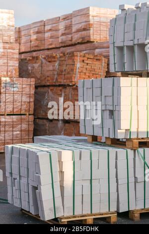 Mehrere Paletten mit Beton Ziegel übereinander im Depot gestapelt. Die industrielle Produktion von Backsteinen. vertikale Foto. Stockfoto