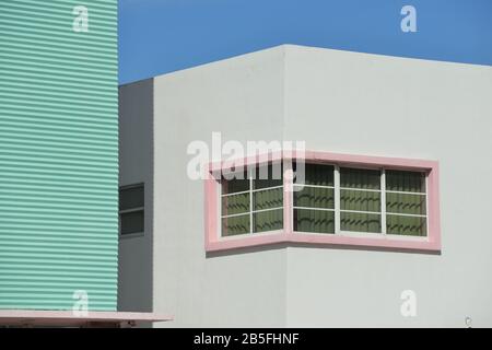 Art-Deco-Wand und Fenster an den Gebäudefassaden von South Beach. Rosafarbene Betonrahmen, gewellte Texturen und geometrische Formen gegen klaren blauen Himmel. Arch Stockfoto