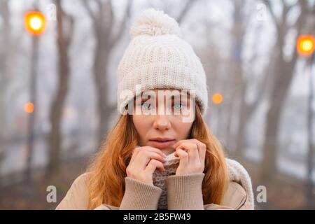 Attraktives junges Mädchen, das am Abend Winterkleidung im Park trägt Stockfoto