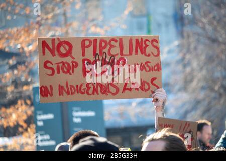 Ottawa, ONTARIO, KANADA - 17. FEBRUAR 2019: Eine Hand hebt bei einem Protestagai ein Schild mit den Worten "keine Pipelines" und "STOP RCMP Invasion on Indigenous Lands" auf Stockfoto