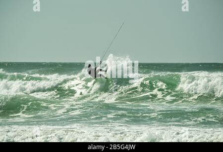 Kitesurfer, der in rauer See bei Lacanau-Océan, Frankreich, über Wellen springt Stockfoto