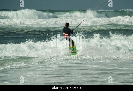 Kitesurfer, der in Lacanau-Océan, Frankreich, durch Wellen und raue Meere reitet Stockfoto