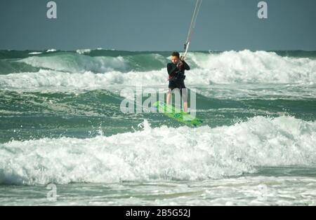 Kitesurfer, der in rauer See bei Lacanau-Océan, Frankreich, über Wellen springt Stockfoto