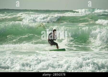 Kitesurfer, der in Lacanau-Océan, Frankreich, durch Wellen und raue Meere reitet Stockfoto