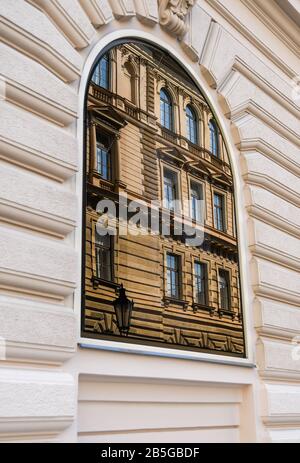 Prag, TSCHECHIEN - JULI 2018: Das alte Gebäude spiegelt sich in einem der großen Bogenfenster des luxuriösen Four Seasons Hotels in der Prager Innenstadt wider. Stockfoto