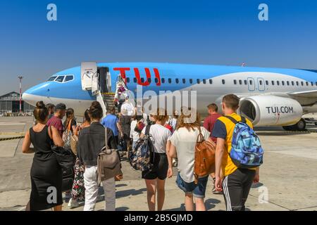 Neapel, ITALIEN - AUGUST 2019: Menschen, die Schlange stehen, um durch die Hintertür eines TUI Boeing 737-Urlaubsstrahls am Flughafen Neapel zu steigen. Stockfoto