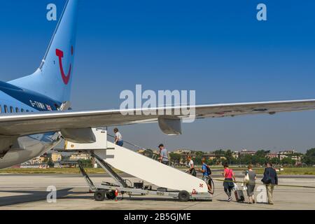 Neapel, ITALIEN - AUGUST 2019: Menschen, die Schlange stehen, um durch die Hintertür eines TUI Boeing 737-Urlaubsstrahls am Flughafen Neapel zu steigen. Stockfoto