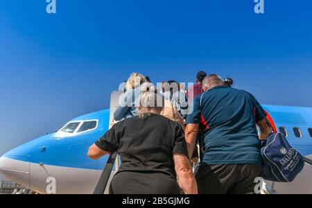 Neapel, ITALIEN - AUGUST 2019: Menschen, die eine Treppe zu den Passagieren klettern, um einen TUI Boeing 737-Urlaubsjet am Flughafen Neapel zu besteigen. Stockfoto