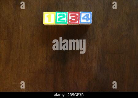 Stapel mit farbigen Holzspielzeugblöcken im Alphabet auf dem Hintergrund Stockfoto