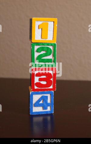 Stapel mit farbigen Holzspielzeugblöcken im Alphabet auf dem Hintergrund Stockfoto