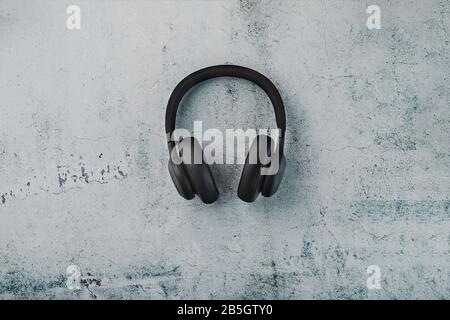 Kabellose schwarze Kopfhörer auf dunklem Hintergrund mit blauer und orangefarbener Hintergrundbeleuchtung. Ohrhörer für Spiele und Musiktitel. Modus Stockfoto
