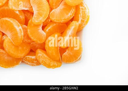Saftige orangefarbene Scheiben MANDARIN in einer rechteckigen weißen Platte auf weißem Hintergrund. Isolieren. Das Konzept des gesunden Essens. Stockfoto