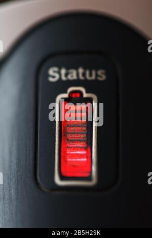 Der Status der Batterie auf dem Gerät mit roter LED-Hintergrundbeleuchtung. Das Konzept von Ladung und Energie Stockfoto