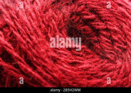 Nahaufnahme aus Wollgarn bunter roter Faden für Handarbeit in Makro. Gewebe aus Hintergrundtextur zum Stricken der Nadel. Vollbildwolle Garn. Stockfoto