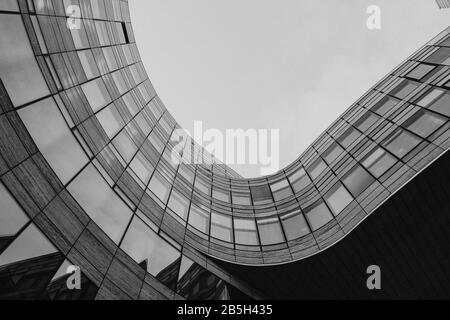 Niedrige Winkelansicht an der plaza zwischen dem Kö-Bogen-Gebäude mit Krümmungsfreier Form Umrissform. Schwarz-weiß abstrakte Außenfassade. Stockfoto