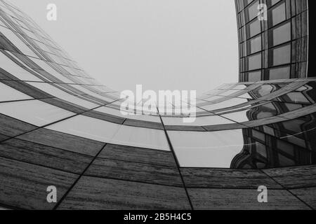 Niedrige Winkelansicht an der plaza zwischen dem Kö-Bogen-Gebäude mit Krümmungsfreier Form Umrissform. Schwarz-weiß abstrakte Außenfassade. Stockfoto