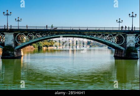 Puente de Isabel II (oder Puente de Triana), eine Brücke, die den Canal de Alfonso XIII überspannt und das Viertel Triana mit dem Stadtzentrum verbindet. Stockfoto