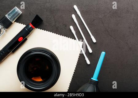 Eine Reihe von Tools, mit denen Sie Ihre Kameralinsen auf dunklem Hintergrund pflegen können. Reinigen der Kamera. Die Ansicht von oben Stockfoto