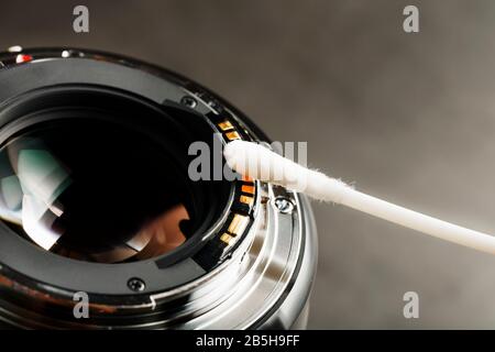 Sanfte Reinigung mit einem Wattestäbchen Kamera-Objektiv mit schöner optischer Block-Nahaufnahme. Makro Im Vollbildmodus Stockfoto