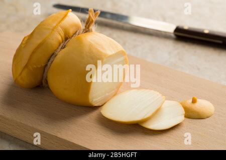 Italienische Scamorza Affumicata und Scheiben schließen sich auf einem Schneidebrett Stockfoto