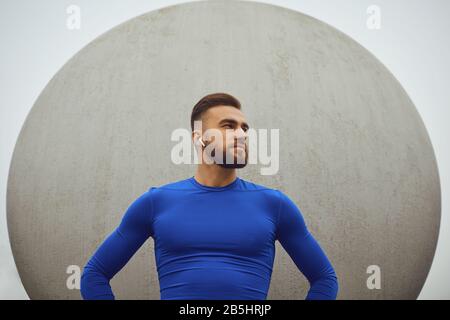 Bärtiger Kerl in Sportkleidung auf grauem Hintergrund. Sport Lifestyle. Stockfoto