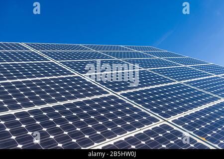 Nahaufnahme, Detailansicht der Sonnenkollektoren eines Solarkraftwerks in wolkenlosem und hellblauem Himmel Stockfoto