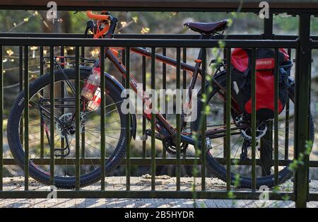 Helsinki, Finnland - 27. April 2019: Abenteuerbike mit Mountainbike-Möglichkeiten und Radtouren und roten Radlern, die auf der Brücke am Fahrrad befestigt sind. Stockfoto