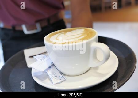 Junge Person, die späten Kaffee im Café serviert, Stockfoto