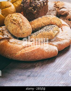 Backwarenkonzept. Brotlaiensortiment auf Holz. Traditionelles Badehaus, vertikal Stockfoto