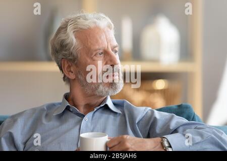 Nachdenklicher älterer Mann lot in Ferndenken oder Trauer Stockfoto