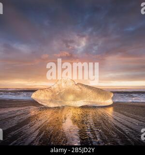 Wunderschöner Sonnenuntergang über dem berühmten Diamond Beach, Island. Dieser Sand Lava Strand ist voll von vielen riesigen Eis-Juwelen, in der Nähe der Gletscherlagune Jokulsarlon Ice Stockfoto