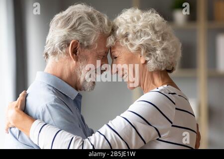Lächelnder reifer Ehemann und Ehefrau teilen gemeinsam einen romantischen Moment Stockfoto