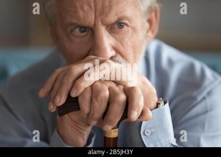 Trauriger behinderter alter Mann hat viel in Gedanken zu Hause Stockfoto