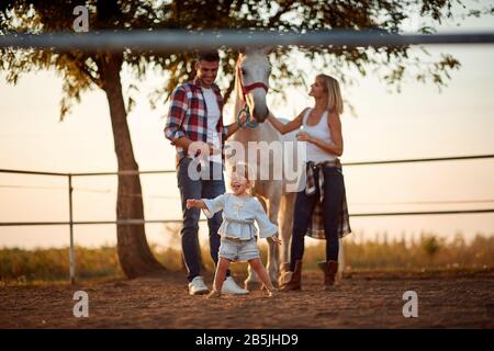 Kleine lächelnde Mädchen haben Spaß auf der Pferdefarm. Stockfoto