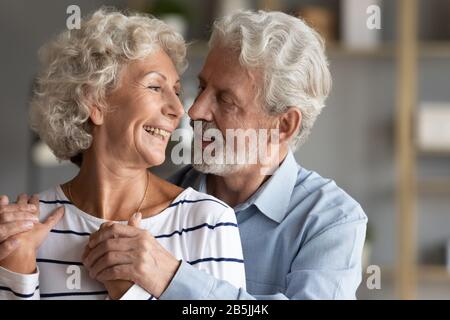 Glücklicher reifer Ehemann und Frau umarmen sich, zusammen einen zärtlichen Moment zu haben Stockfoto